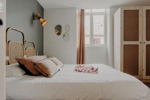a bedroom with a large white bed with flowers on it at Hôtel PALMITO in Biarritz