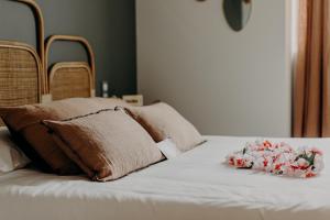 a bed with two pillows and flowers on it at Hôtel PALMITO in Biarritz