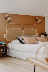 a bedroom with a bed with two lights on the wall at Hôtel PALMITO in Biarritz