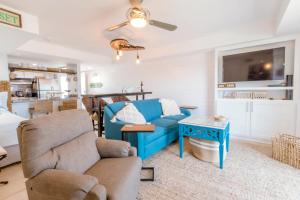 ein Wohnzimmer mit einer blauen Couch und einem Tisch in der Unterkunft Stunning Ocean Views STEPS from the Beach with Pool! Fabulous 4th Floor Studio! in New Smyrna Beach + 17 Fotos