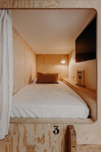 a bed in a small room with a tv at Hôtel PALMITO in Biarritz