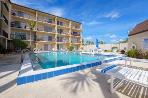 a swimming pool in front of a hotel at Seaside Hideaway STEPS from the Beach with Ocean View Balcony and Pool! in New Smyrna Beach