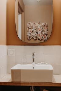 a bathroom with a white sink and a mirror at Hôtel PALMITO in Biarritz
