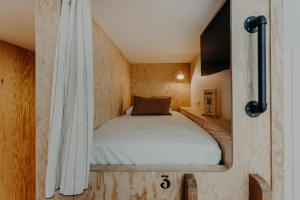 a bed in a small room with a curtain at Hôtel PALMITO in Biarritz