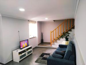 a living room with two blue couches and a tv at Casa da quintinha - Turismo rural in Arcos de Valdevez