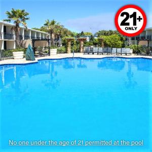 a large blue swimming pool with a sign saying no one under the age at Royal Holiday Beach Resort in Biloxi