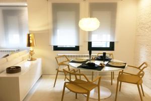 a kitchen and dining room with a table and chairs at Golden & White Home in Santiago de Compostela