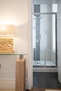 ein Bad mit einer Glasdusche und einem Glastisch in der Unterkunft Luxury Seaside Apartment in Eastbourne