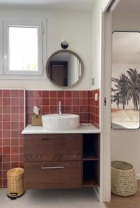 a bathroom with a sink and a mirror at Hôtel PALMITO in Biarritz +34 photos