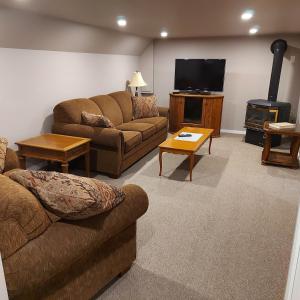 sala de estar con 2 sofás y TV de pantalla plana en Quails Roost, en Summerland