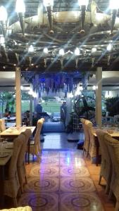une salle à manger avec des tables et des chaises ainsi qu'un court de tennis dans l'établissement Greek House Hotel, à Neos Marmaras