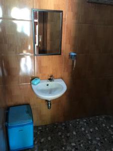 a bathroom with a sink and a mirror and a trash can at Private Villa Dekke Boru, Bogor in Bogor