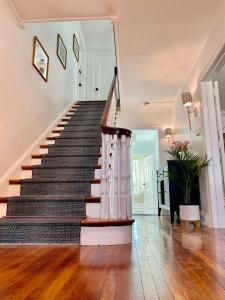 a staircase in a home with wooden floors at Buttonwood Boutique Hotel in West Cape May