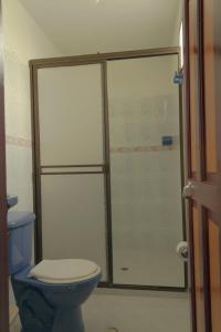 a bathroom with a blue toilet and a shower at Hotel Felicina in Jeric&oacute;
