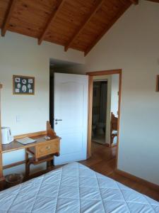a bedroom with a bed and a desk and a door at Hostería Patagonia Jarke in Ushuaia