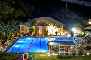 una casa con piscina por la noche en Hotel Fazenda Santa Barbara, en Engenheiro Paulo de Frontin