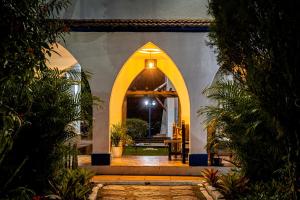 une entrée dans un bâtiment avec une arche dans l'établissement Hotel Fazenda Santa Barbara, à Engenheiro Paulo de Frontin