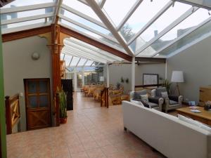 a conservatory with a glass roof with chairs and tables at Hostería Patagonia Jarke in Ushuaia