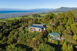 an aerial view of a house on a hill next to the ocean at Karu ō te Kiwi in Pakawau