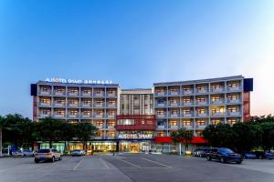 a large building with cars parked in a parking lot at Ausotel Smart Guangzhou Baiyun International Airport Terminal 2, Canton Fair Free Shuttle 15 Apr to 4 May in Guangzhou