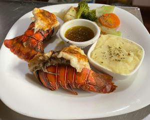 a white plate of food with lobster and sauce at Clusia Lodge in El Copey