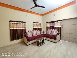 uma sala de estar com um sofá e duas janelas em Vizag homestay guest house em Visakhapatnam