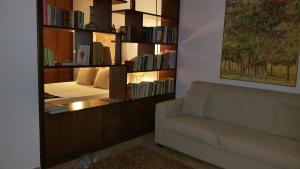 a living room with a couch and a book shelf with books at B & B Villa Flora in Mondello