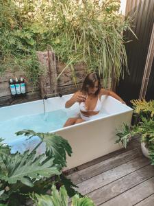 a woman sitting in a bathtub in a garden at The Cove Jervis Bay in Jervis Bay Village