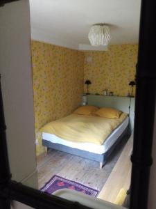 a bedroom with a bed with yellow wallpaper at La Forge in Arcis-le-Ponsart