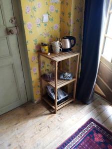 a small wooden shelf in the corner of a room at La Forge in Arcis-le-Ponsart