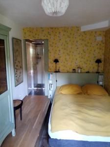 a bedroom with a bed and a yellow wall at La Forge in Arcis-le-Ponsart