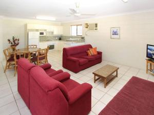 a living room with two red couches and a table at Alma Bay Holiday Unit 4 in Arcadia