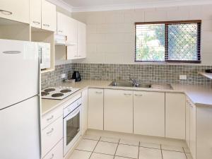 a kitchen with white cabinets and a sink at Alma Bay Holiday Unit 4 in Arcadia