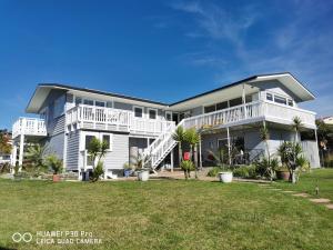 a large white house with a lawn in front of it at Geyser Lookout BnB in Rotorua