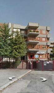 ein Gebäude mit einem roten Zaun vor einem Parkplatz in der Unterkunft B&B La maison foggia in Foggia