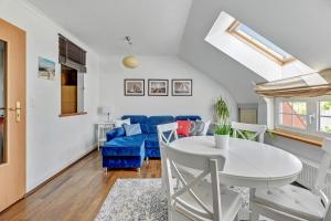uma sala de estar com uma mesa branca e um sofá azul em Lion Apartments - Santorini Studio em Sopot