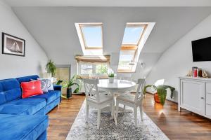 uma sala de estar com um sofá azul e uma mesa em Lion Apartments - Santorini Studio em Sopot