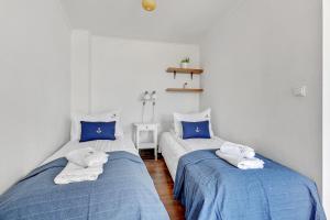 duas camas num quarto com azul e branco em Lion Apartments - Santorini Studio em Sopot
