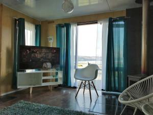 a living room with a television and a chair at Casa Pascual in Dalcahue