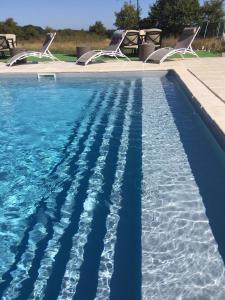 una piscina con sillas y agua azul en Fonclaire Holidays Carpers Rest, en Blond