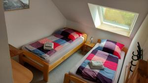 two twin beds in a small room with a window at Hofcafé & Ferienhof Akkens in Greetsiel