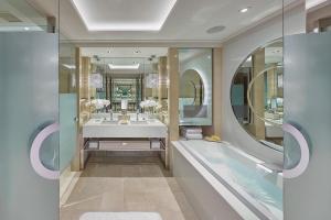 a bathroom with a tub and a sink and a mirror at Crown Towers Melbourne in Melbourne
