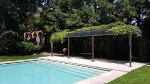a swimming pool with a gazebo next to a house at Villa Bottini La Limonaia in Robecco dʼOglio