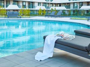 una manta sentada en un banco junto a una piscina en PARKROYAL Monash Melbourne, en Clayton North