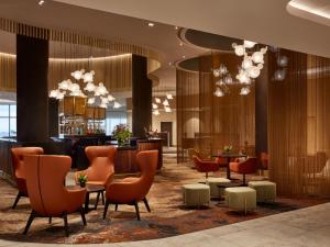 a lobby with chairs and tables and a bar at PARKROYAL Monash Melbourne in Clayton North