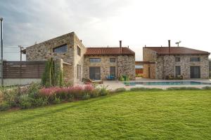 a large stone house with a yard and a pool at Villa Evinoi in Pallini