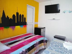 a bedroom with a colorful bed and a tv at Cabañas 7 Colores in San Andrés