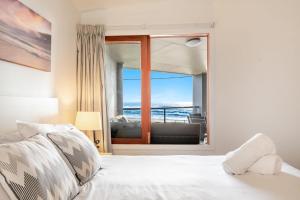 een slaapkamer met een bed en uitzicht op de oceaan bij Sea Breeze - Lennox Head in Lennox Head