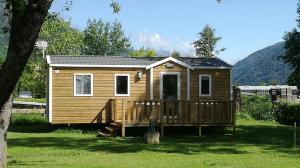 een klein houten huisje met een houten terras bij Camping Chantecler in Luchon
