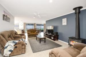 a living room with two couches and a fireplace at Family Vibes By Middleton Beach- Free Wifi in Middleton